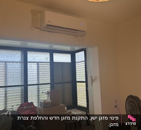 מזגן מותקן על קיר בחדר עם חלון גדול